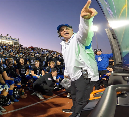 group of athletes paying attention to coach Rob Zvonar as he explains a strategy on a Bretford Cordless Explorer display cart