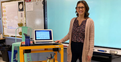 a teacher standing next to a Bretford MIC cart in a classroom